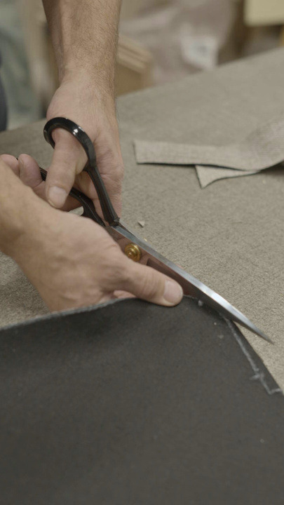 A Linea-D employee cutting upholstery fabric by hand