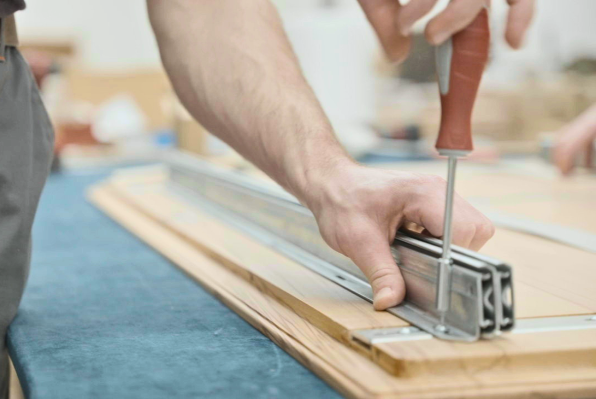 A Linea-D table component being assembled by hand